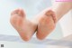 A close up of a woman's bare feet in a bathtub.