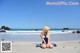 A woman sitting on a beach next to the ocean.