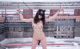 A naked woman wearing a cat mask on top of a building.
