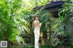 A woman in a white dress standing in a garden.