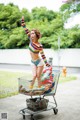 A woman standing on top of a shopping cart.